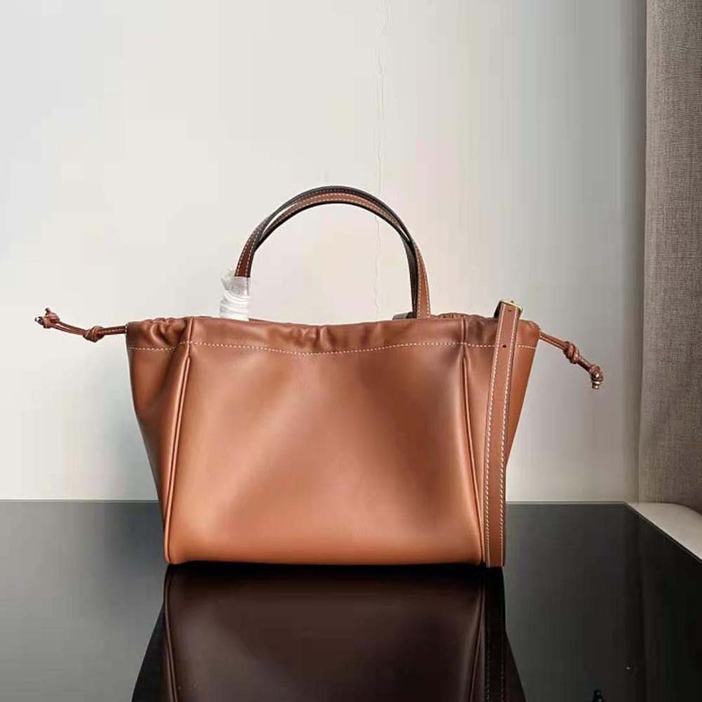 Side angle showing drawstring closure and strap on Celine Women Small Cabas Drawstring Cuir Triomphe