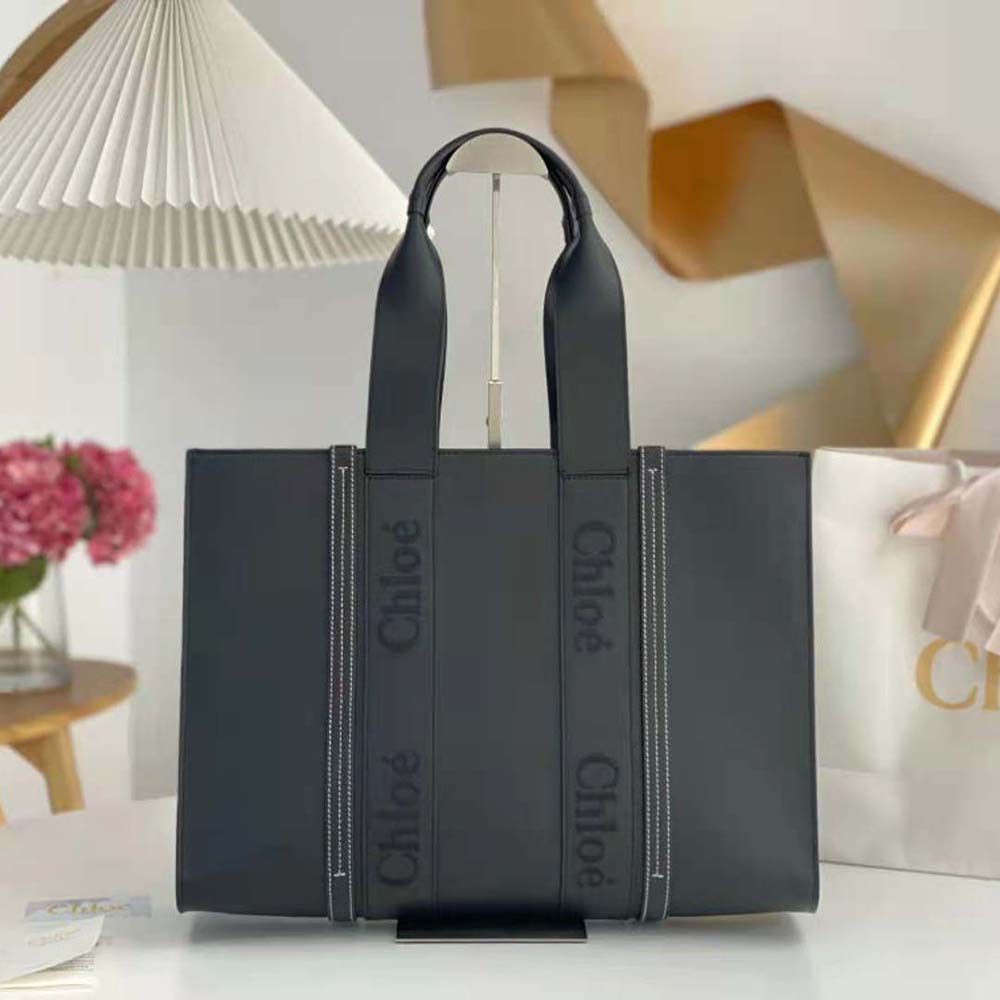 Close-up of gold-tone hardware and embroidered Chloé logo on black leather tote