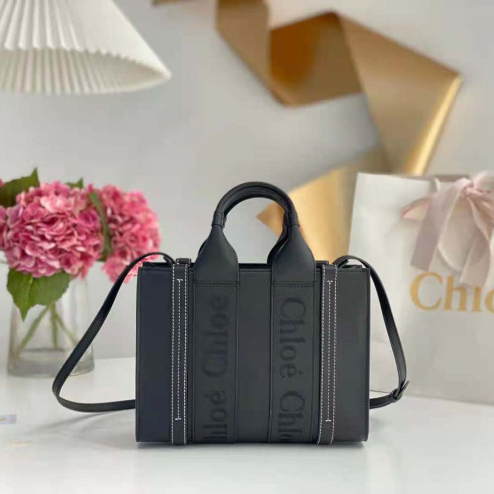 Close-up of embroidered Chloé logo and antique gold hardware on black Woody tote