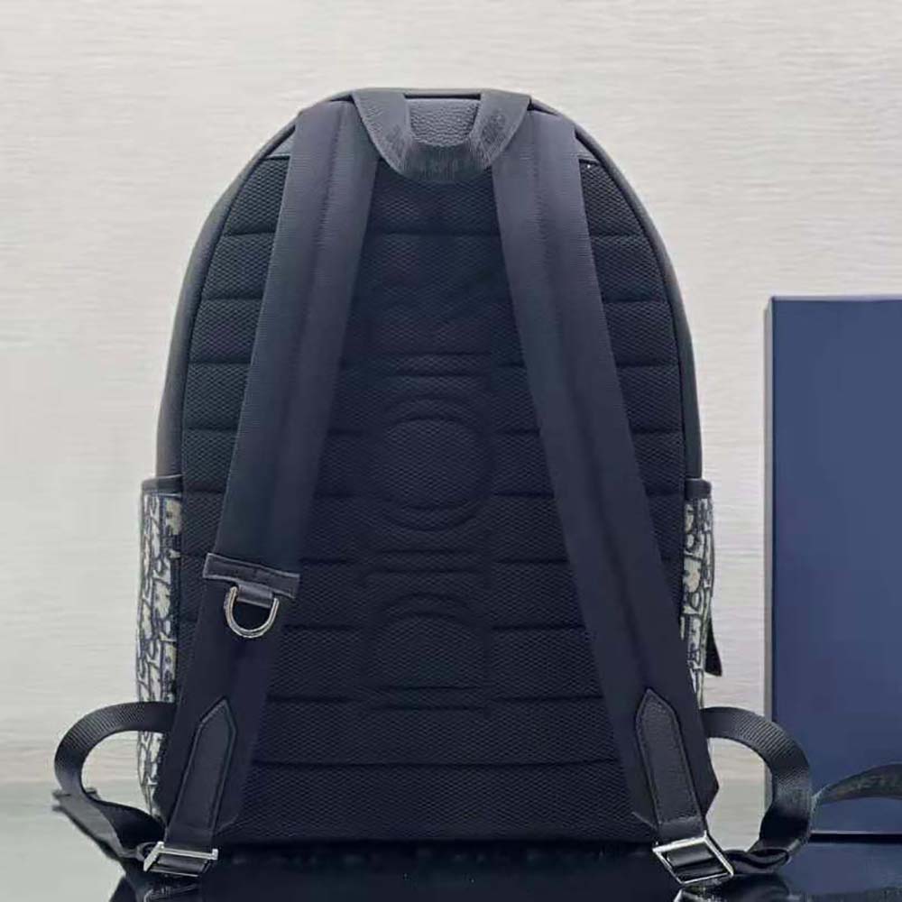 Side profile showing black leather trim on Dior Men Explorer Backpack
