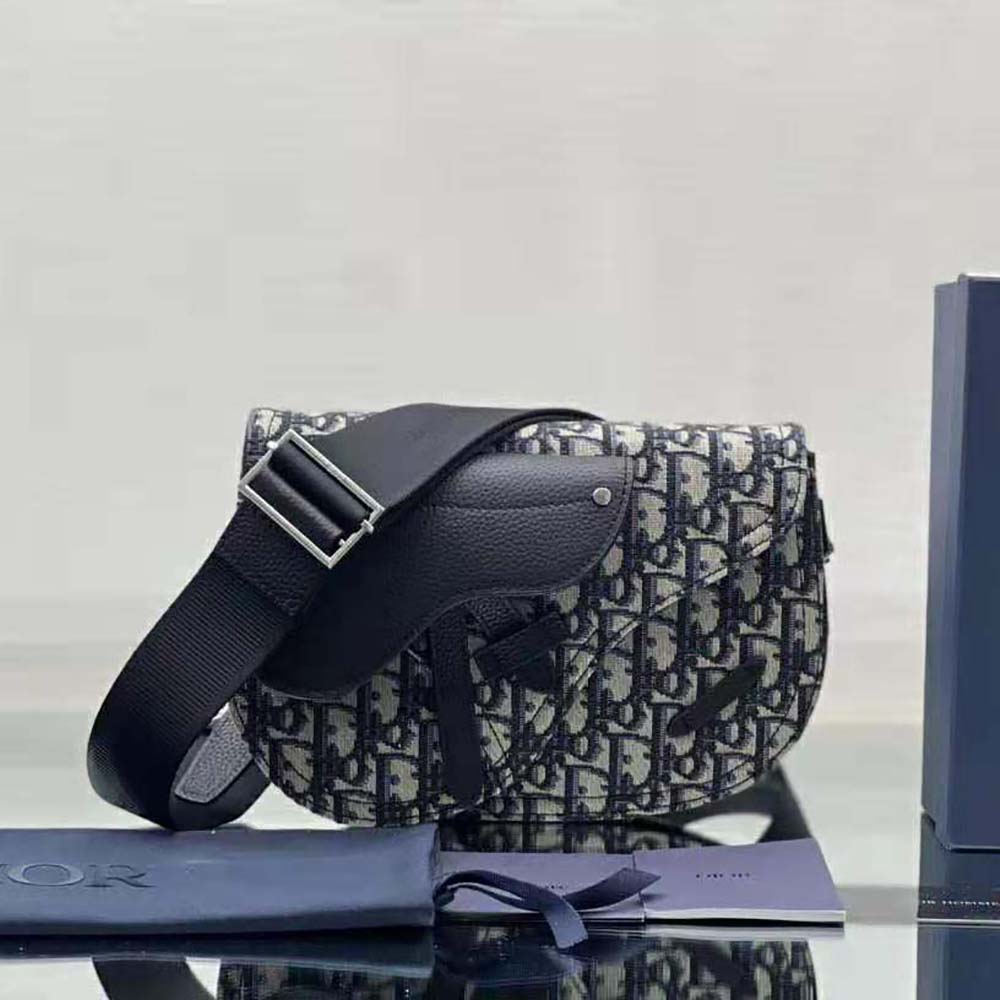Close-up on silver-tone hardware and flap closure of Dior Men Saddle Pouch