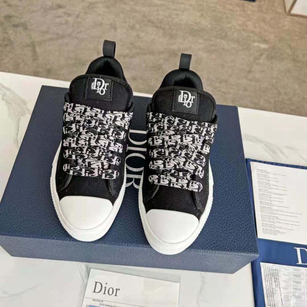 Close-up of Dior signature hardware on black cotton canvas sneaker