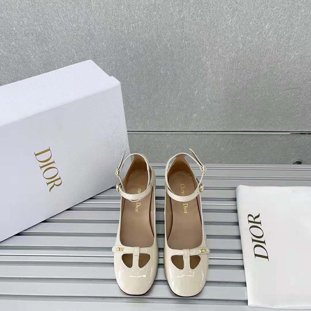 Close-up of Dior logo hardware on white patent calfskin pump
