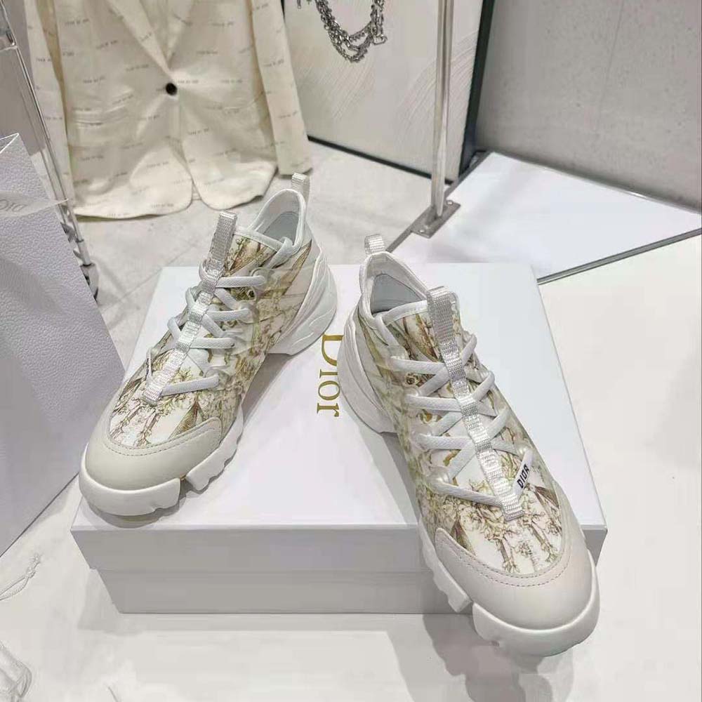 Close-up of gold-tone hardware and Rêve D’Infini print on Dior sneaker