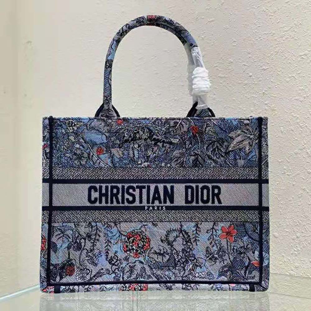 Close-up detail of multicolor Dior Jardin Magique embroidery on blue denim tote