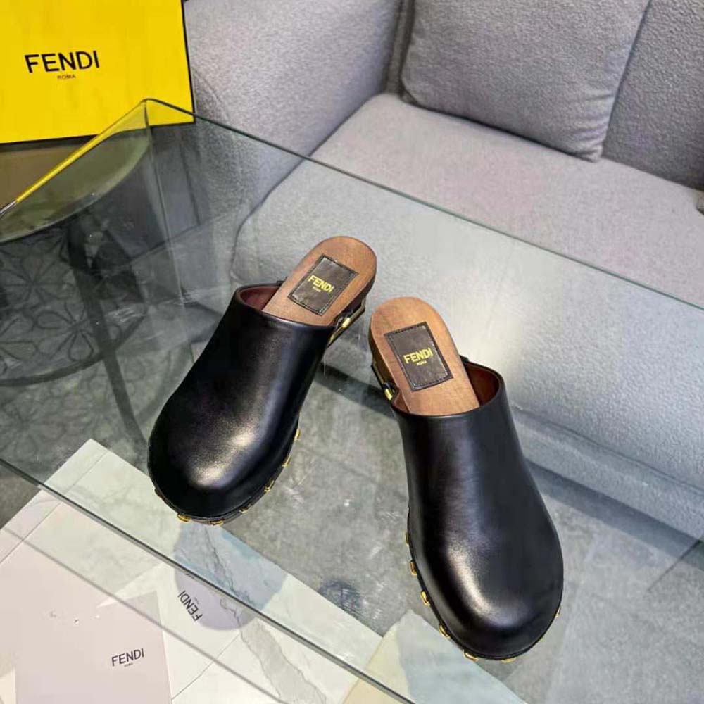 Close-up of gold hardware on Fendi Women Baguette Show Black Leather Medium-Heel Clogs