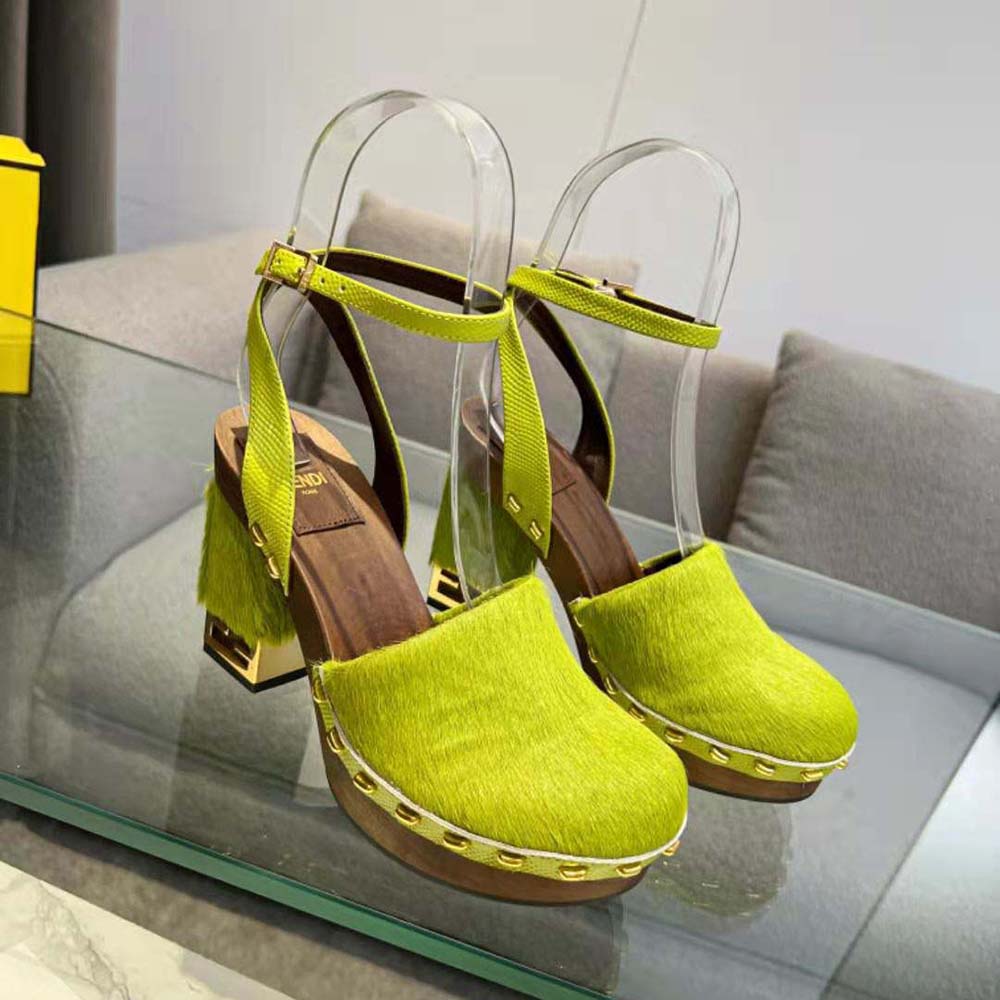 Close-up detail of green pony hair and gold Fendi hardware on clogs