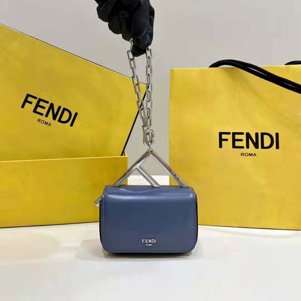Close-up of gold-tone Fendi logo hardware on blue leather mini-bag