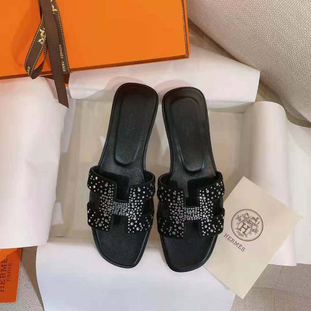 Close-up of Hermes signature hardware on Oasis Sandal black suede