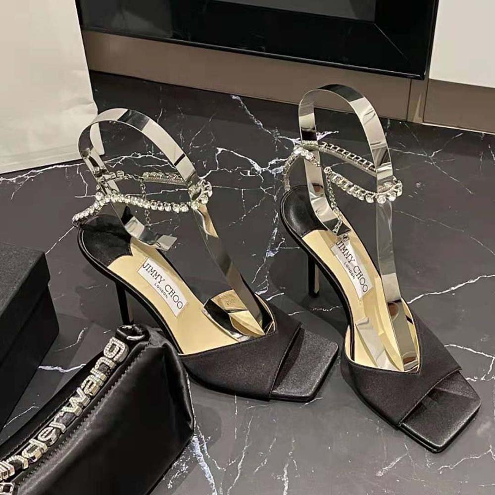 Close-up on crystal embellishment of Jimmy Choo Women Saeda Sandal 100 Black Suede