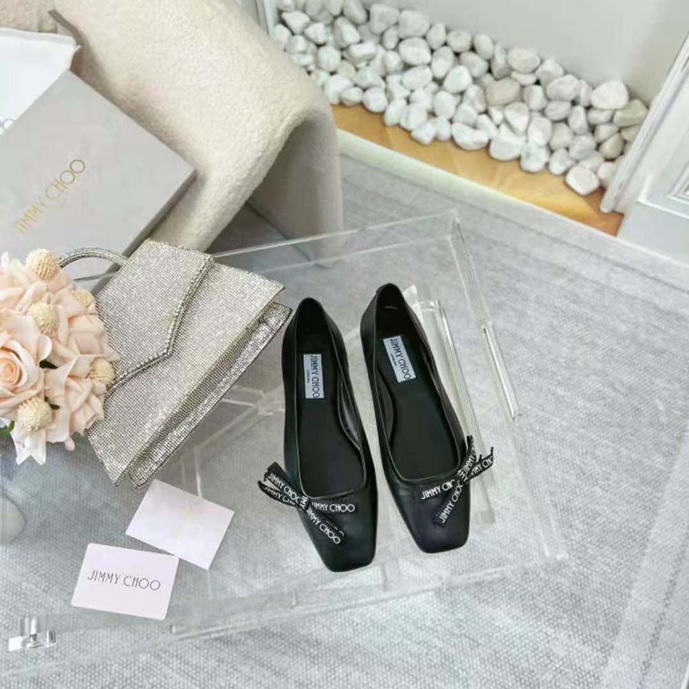 Close-up of signature Jimmy Choo bow on black nappa leather flats