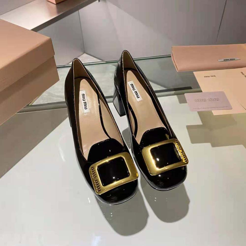 Close-up on signature hammered buckle detail of Miu Miu black pumps