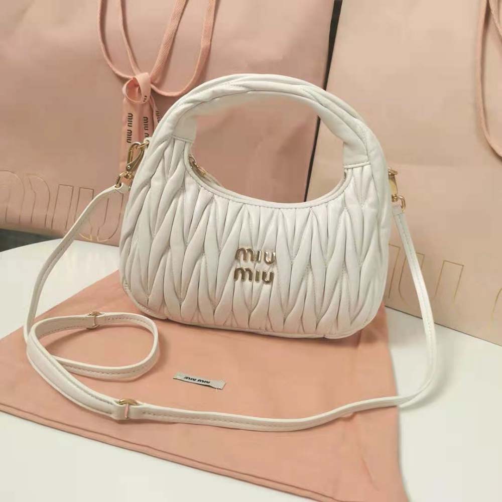 Close-up of white matelassé quilting and silver hardware on Miu Miu hobo bag