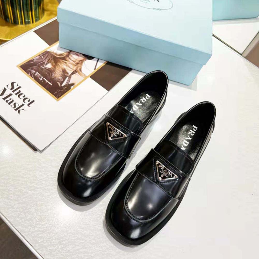 Close-up of black brushed leather and Prada logo detail on loafer