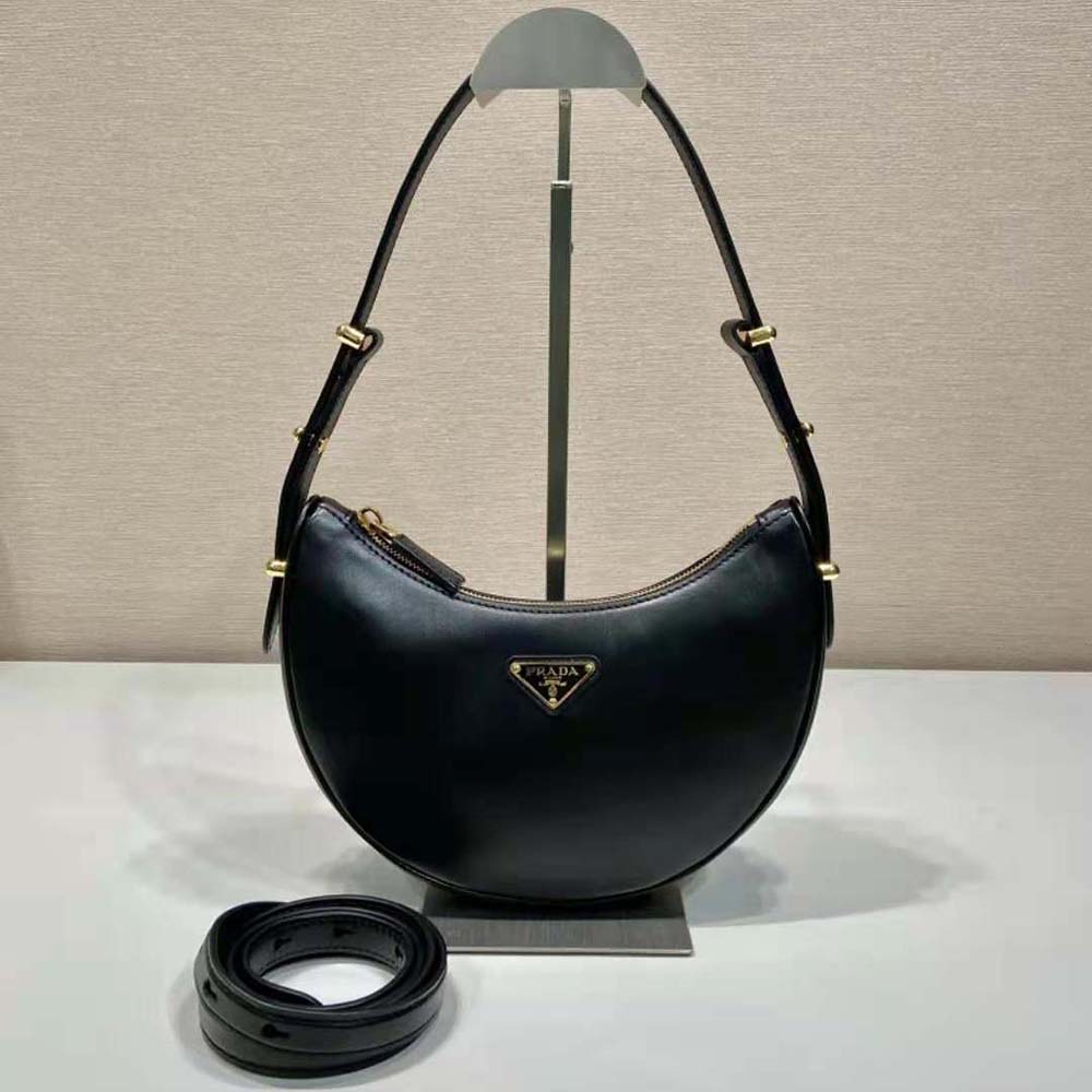 Close-up of black leather texture and enameled triangle logo detail