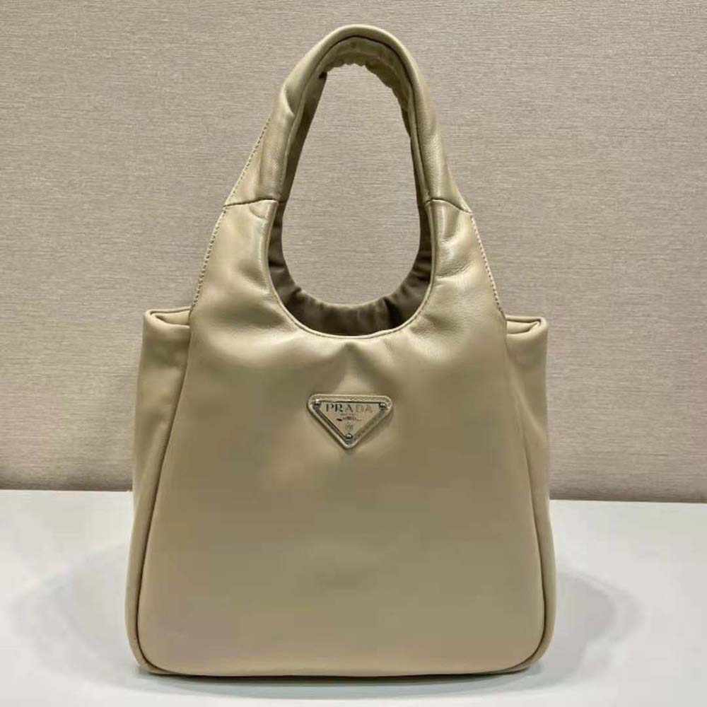 Close-up of silver-tone Prada hardware on beige leather bag