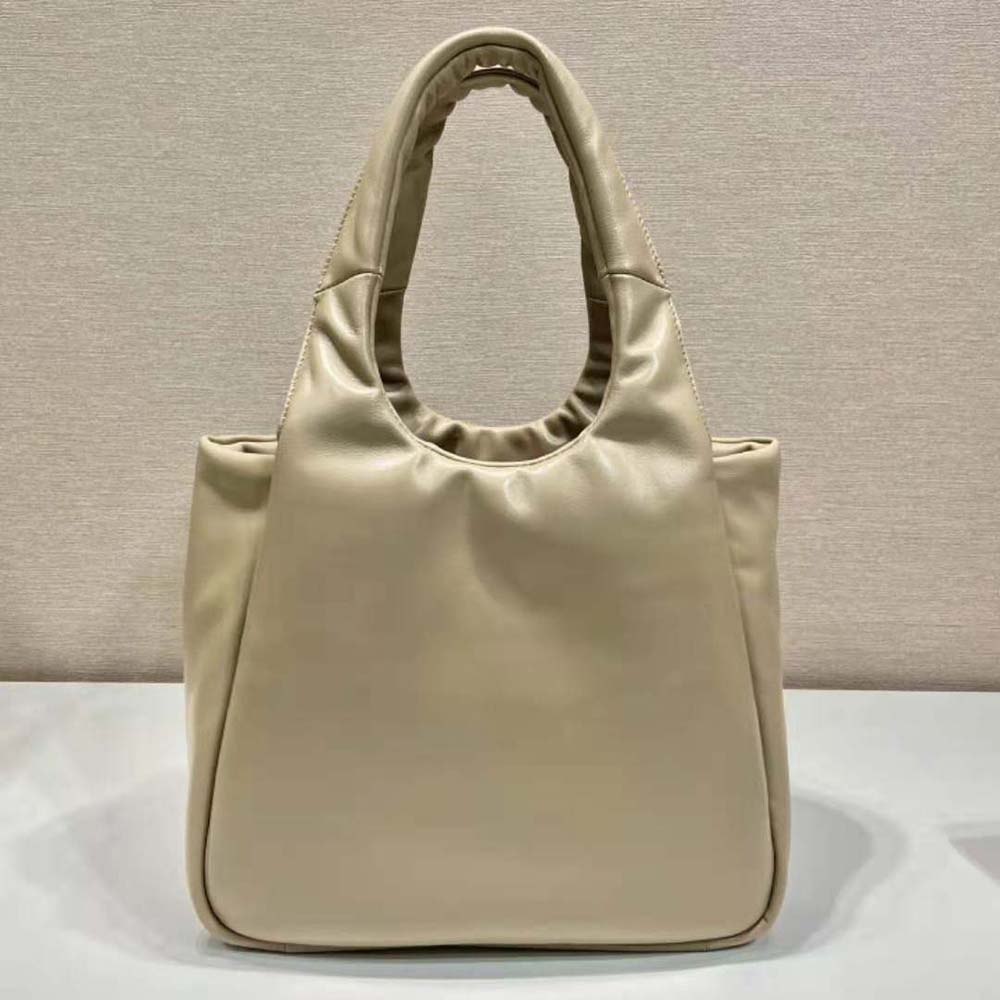 Side angle showing padded silhouette of Prada Women Medium Soft Nappa Leather Bag-Beige