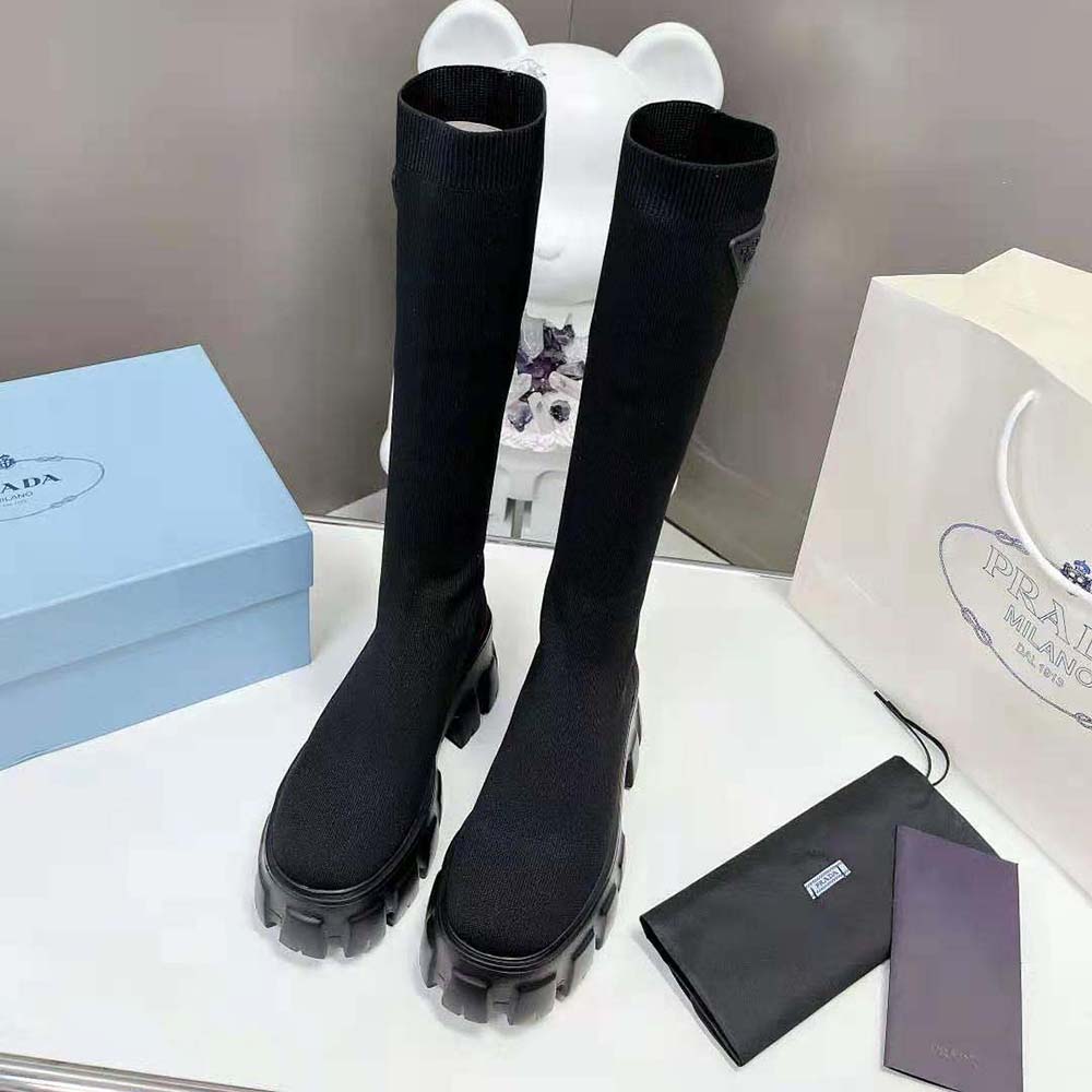 Close-up on embossed rubber triangle logo on Prada Monolith Knit Boots