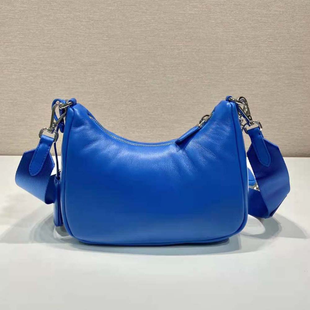 Side angle showing structured silhouette and flap closure of the blue Prada shoulder bag
