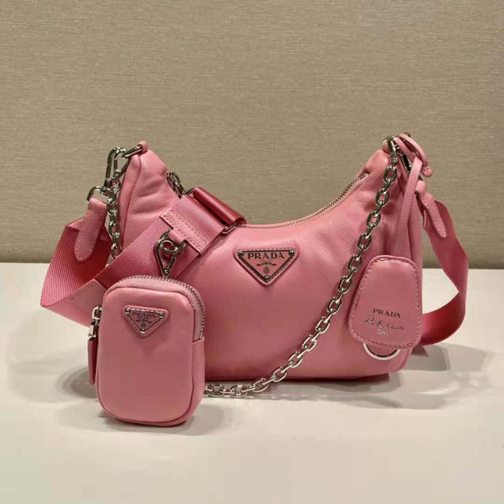 Close-up of gold-tone Prada logo plaque on pink shoulder bag