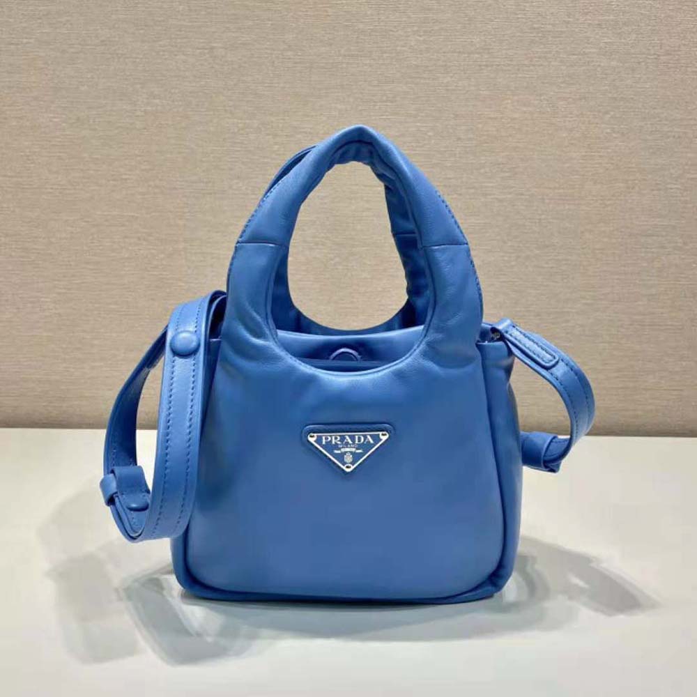 Close-up of quilted padding and silver-tone logo on Prada blue bag
