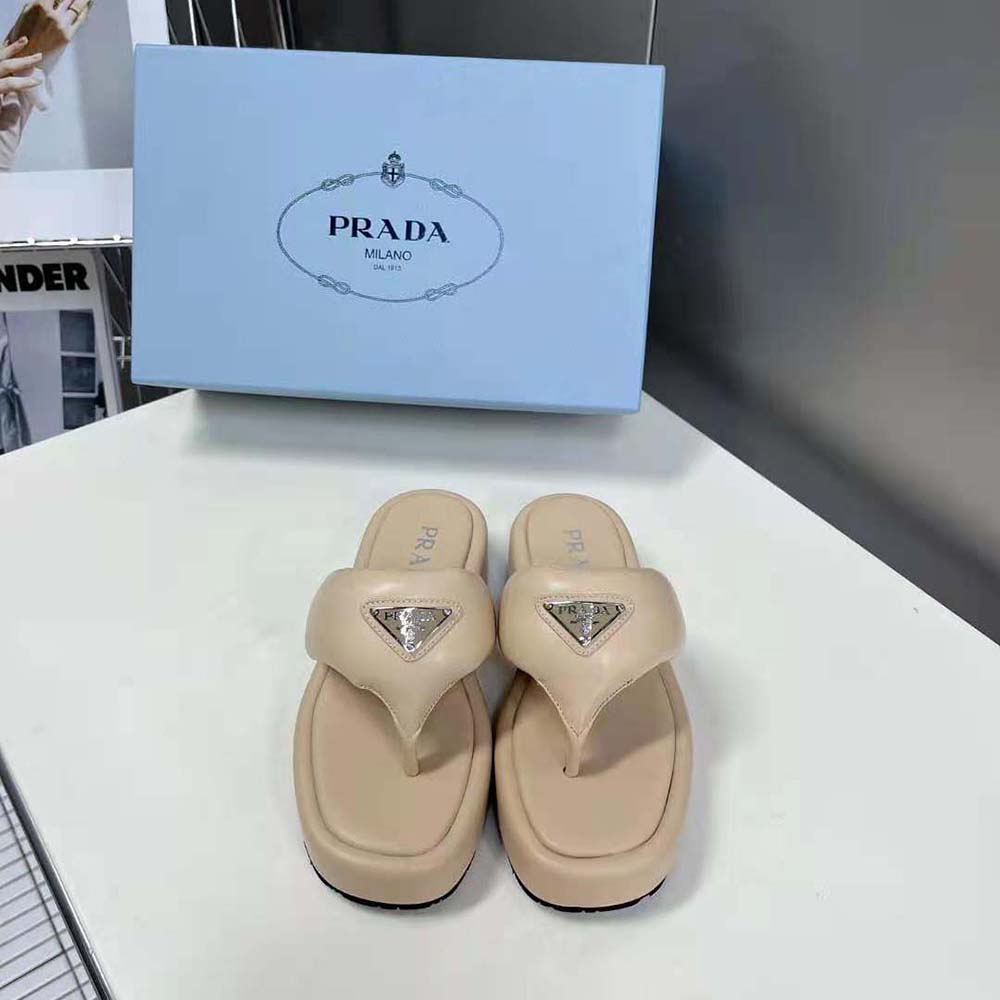 Close-up of gold-tone Prada hardware on thong wedge sandals