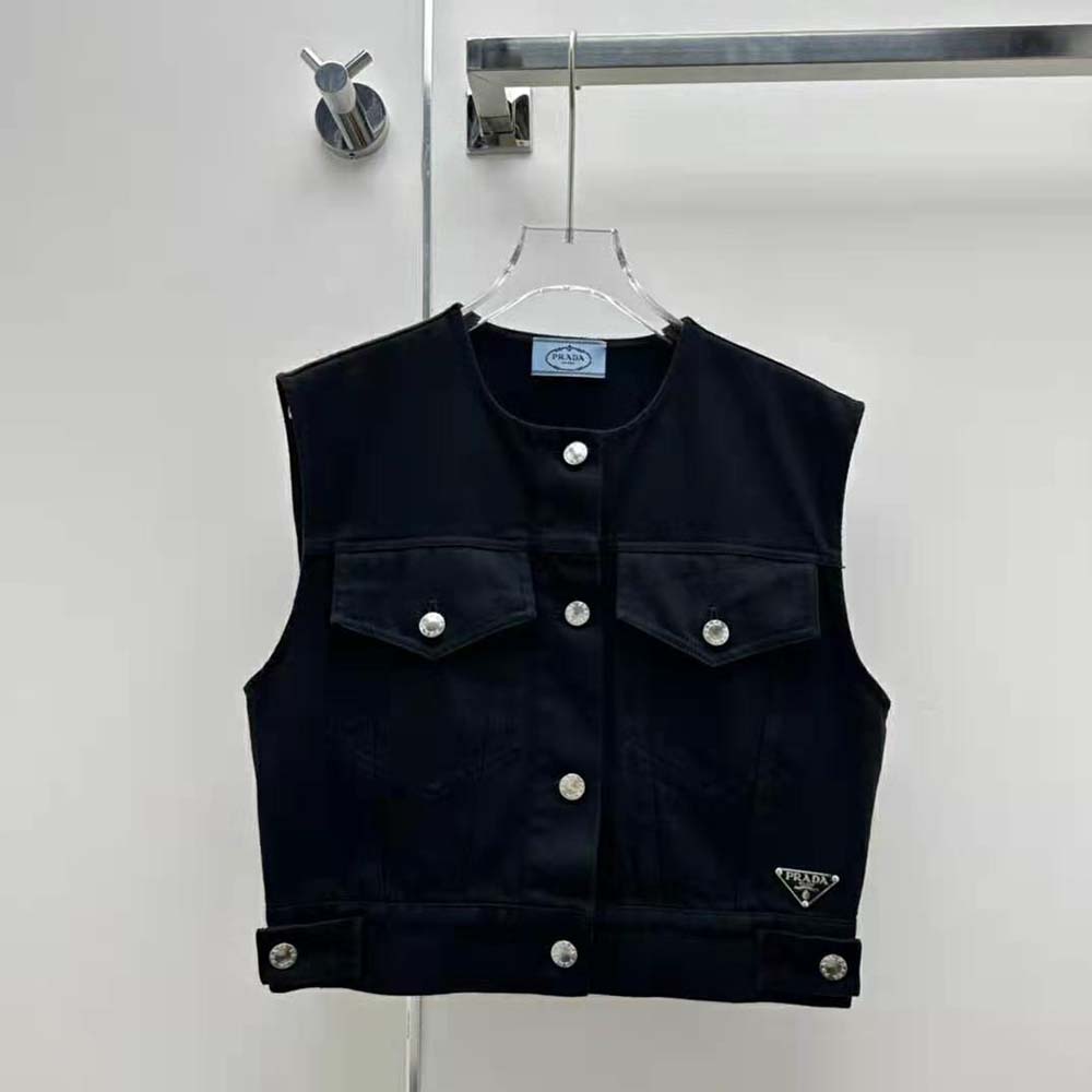 Close-up of Prada triangular logo detail on black denim vest