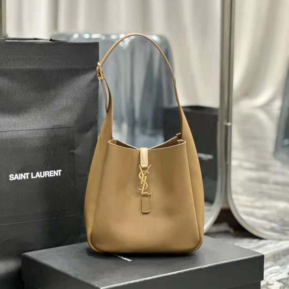Close-up of gold YSL logo hardware on smooth leather bag
