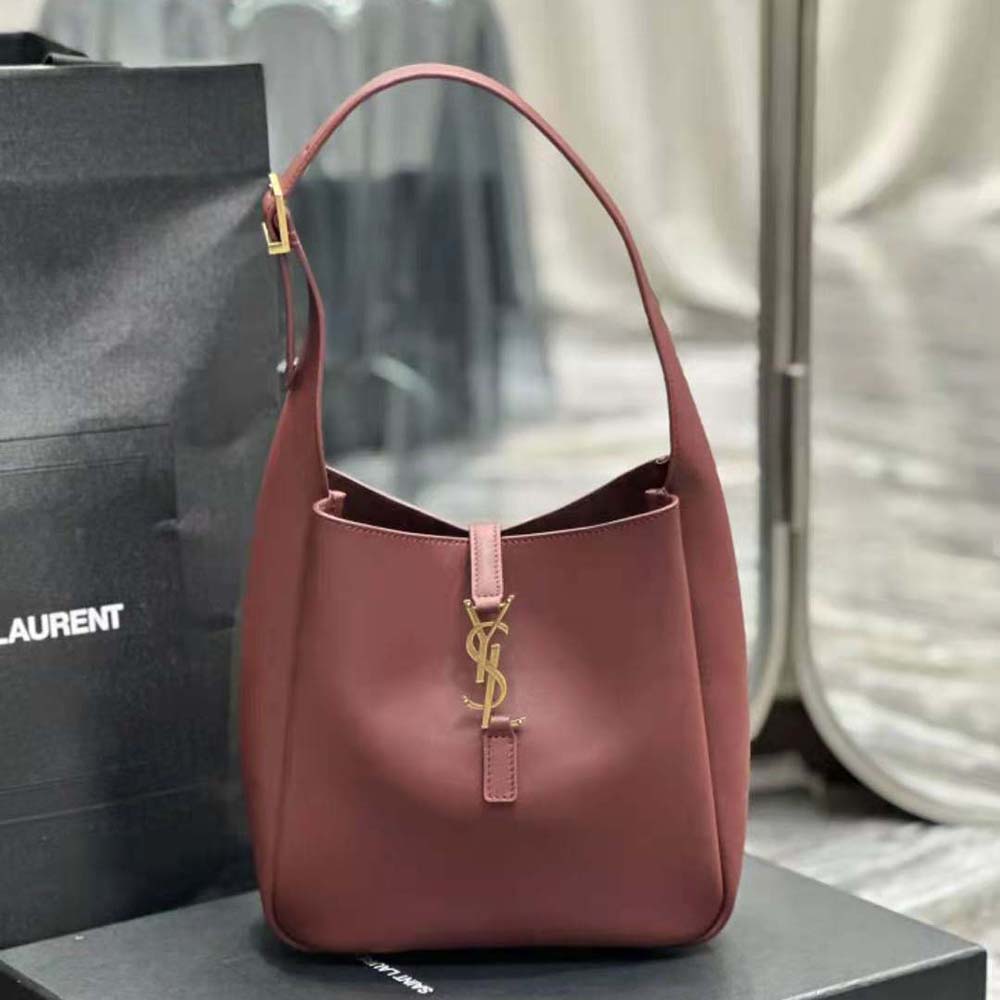 Close-up of gold YSL logo hardware on maroon smooth leather handbag