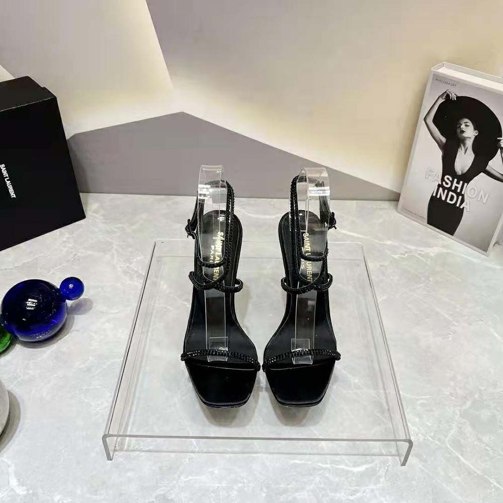 Close-up of rhinestone and gold YSL logo hardware on Opyum Sandals