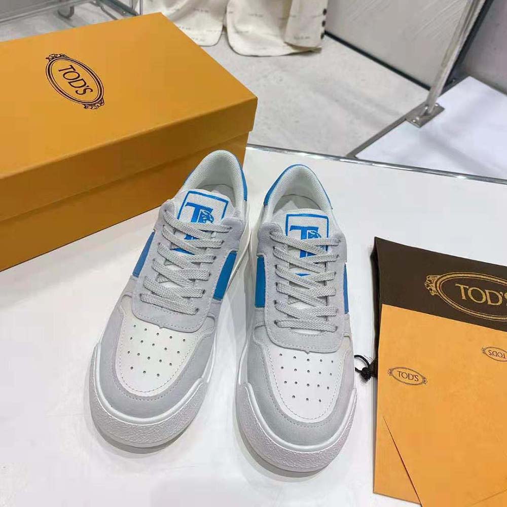 Close-up of blue suede and smooth leather on TODS sneakers