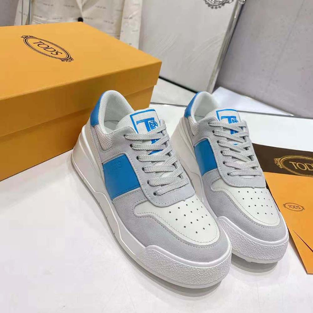Side profile showing Tod’s pebble sole on men’s blue sneakers