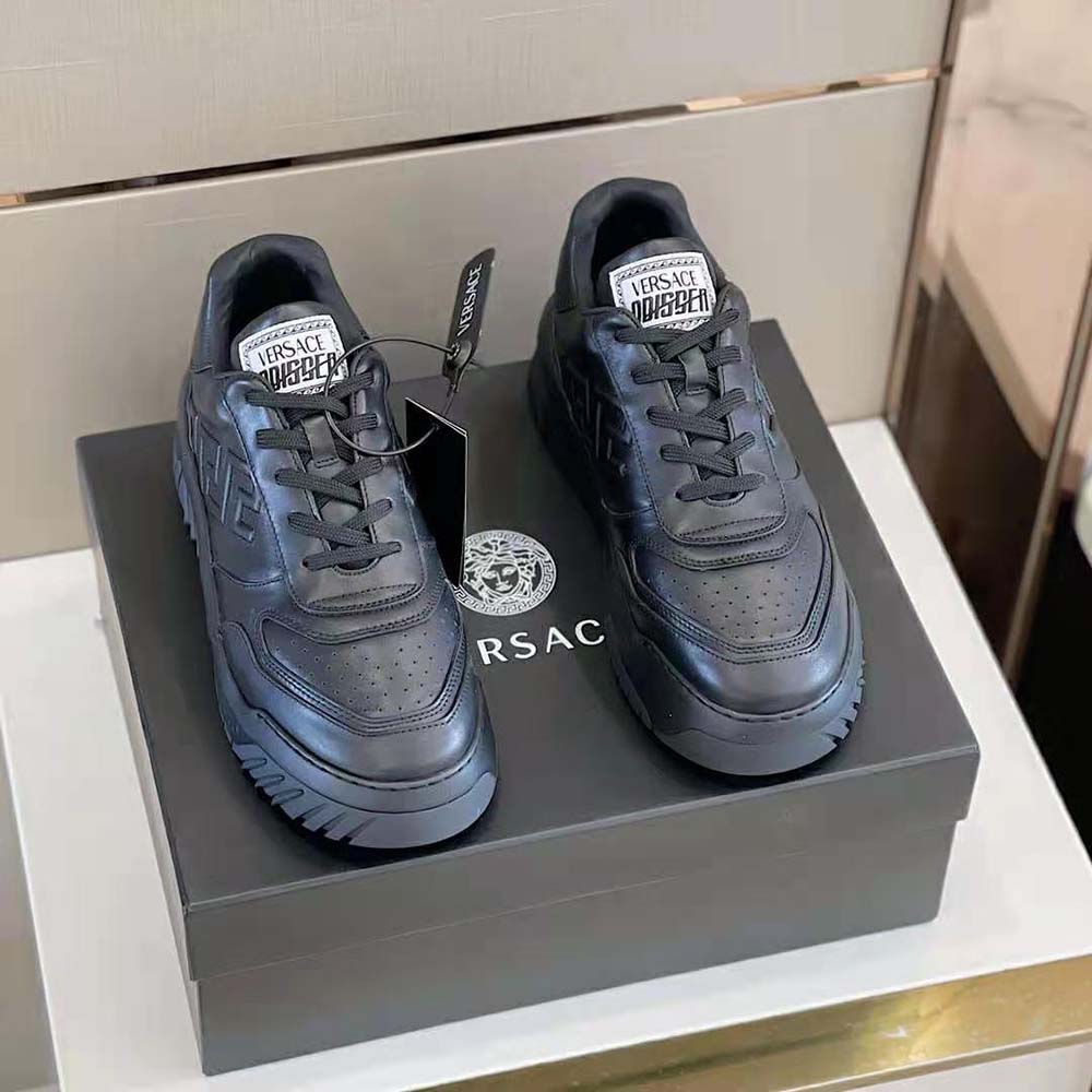Close-up detail of black leather and gold-tone hardware on Versace Men Greca Odissea Sneakers-Black