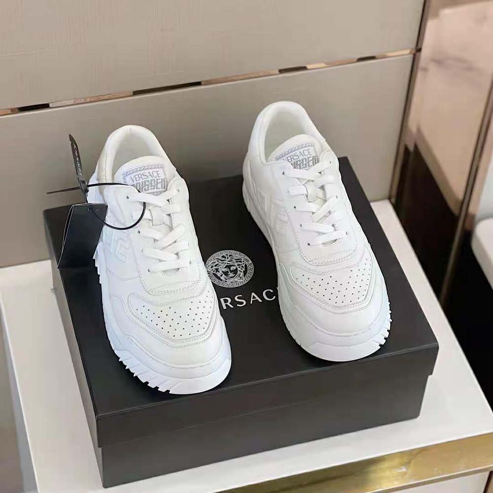 Close-up detail of gold Greca hardware on Versace Men Greca Odissea Sneakers-White