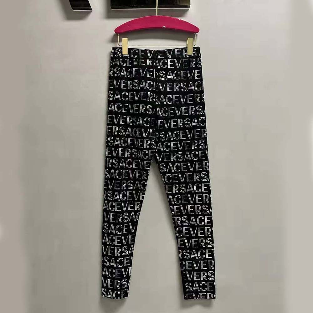 Side angle showing slim fit of Versace Women Crystal Versace Allover Leggings
