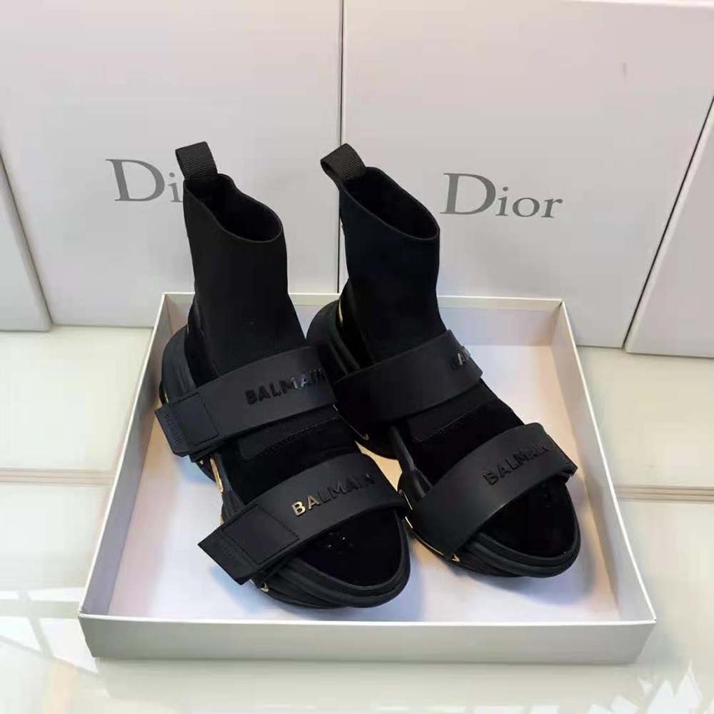 Top view showing adjustable strap and gold Balmain hardware on black trainers