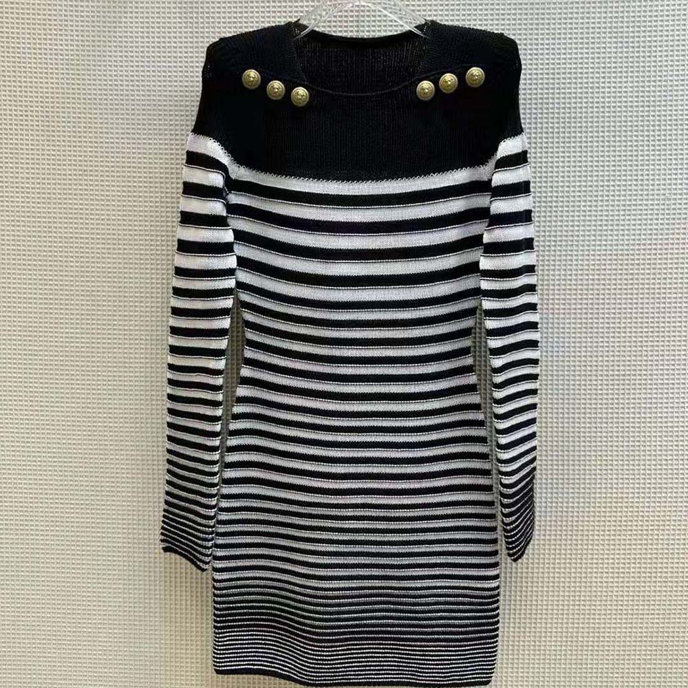 Close-up of signature Balmain hardware on the blue striped knit dress