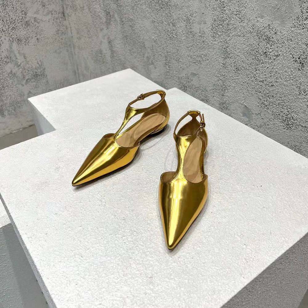 Close-up of gold-tone T-bar strap and laminated leather on ballerina flat