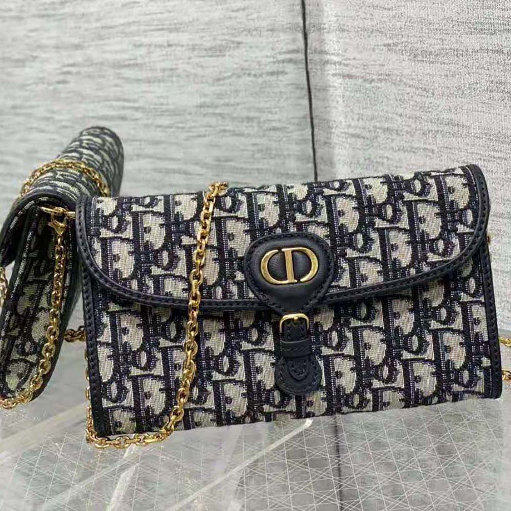 Close-up detail of blue Dior Oblique jacquard fabric and silver chain on Dior Bobby pouch