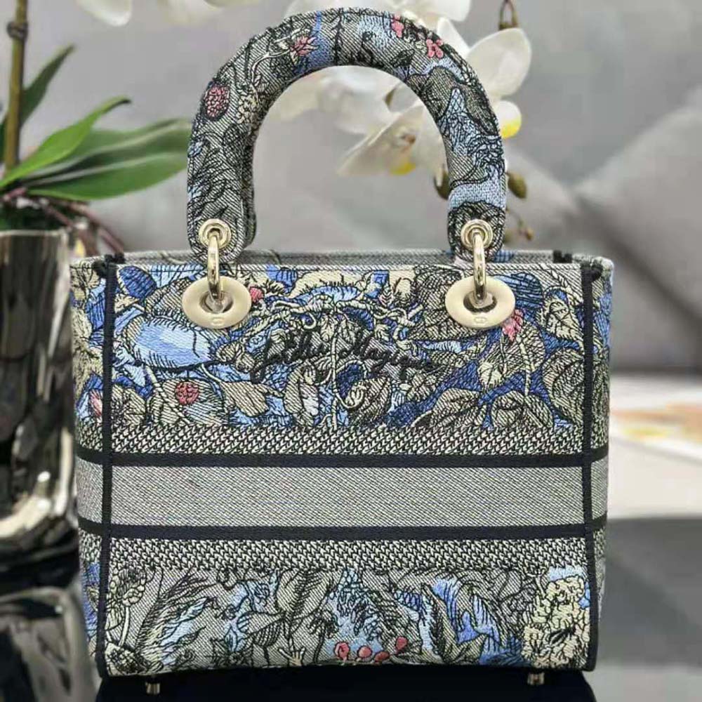 Side profile showing silver hardware and flap closure on Dior Lady D-lite Denim bag