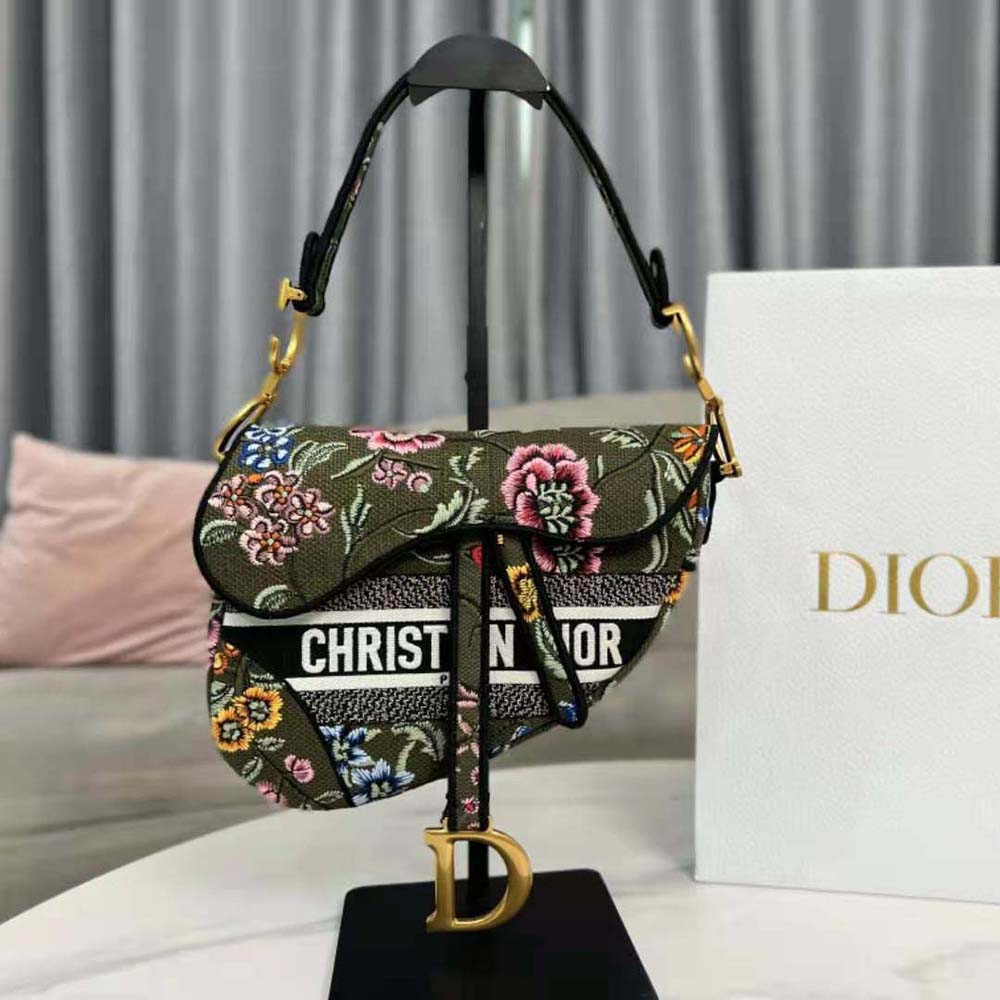 Close-up of gold hardware and Dior charm on the green bag