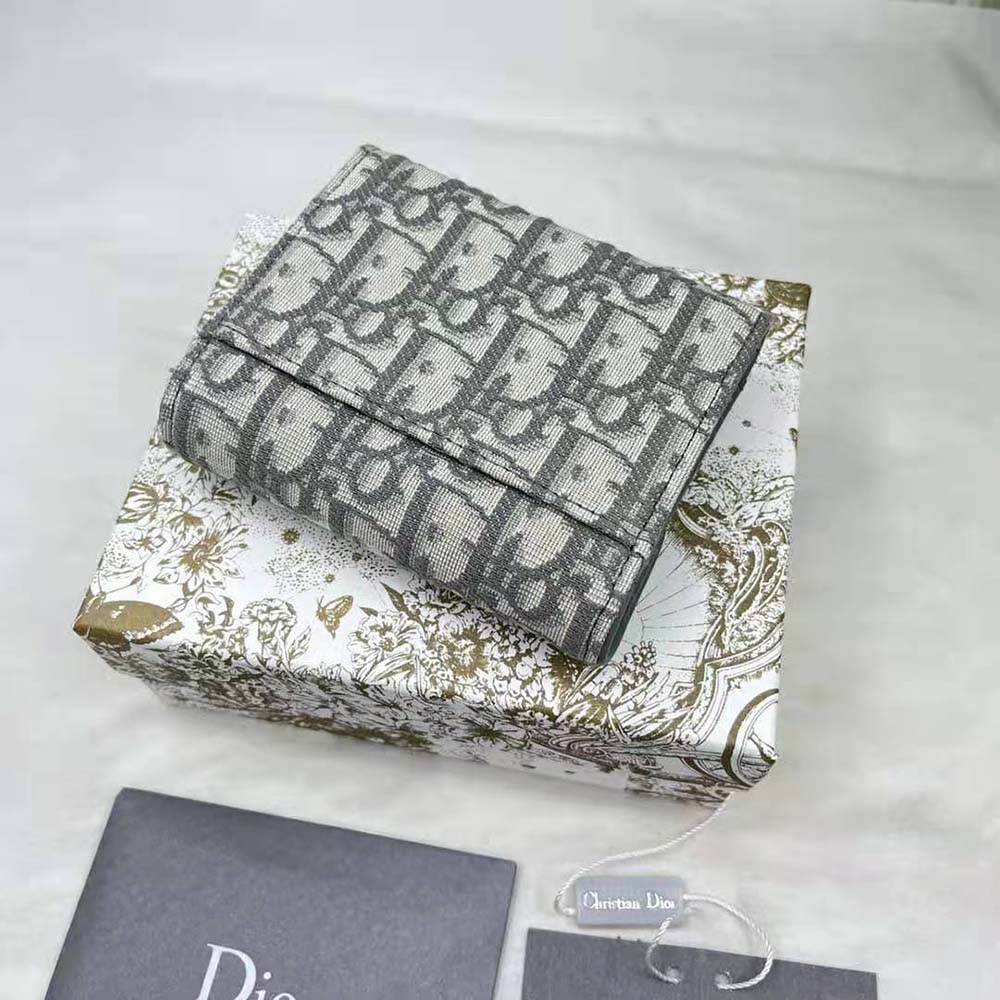 Close-up on flap closure and silver hardware of Dior Women Saddle Lotus Wallet