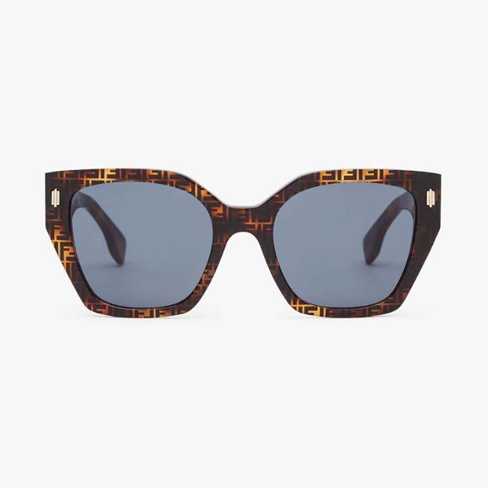 Close-up on gold Fendi logo hardware on brown acetate frame sunglasses