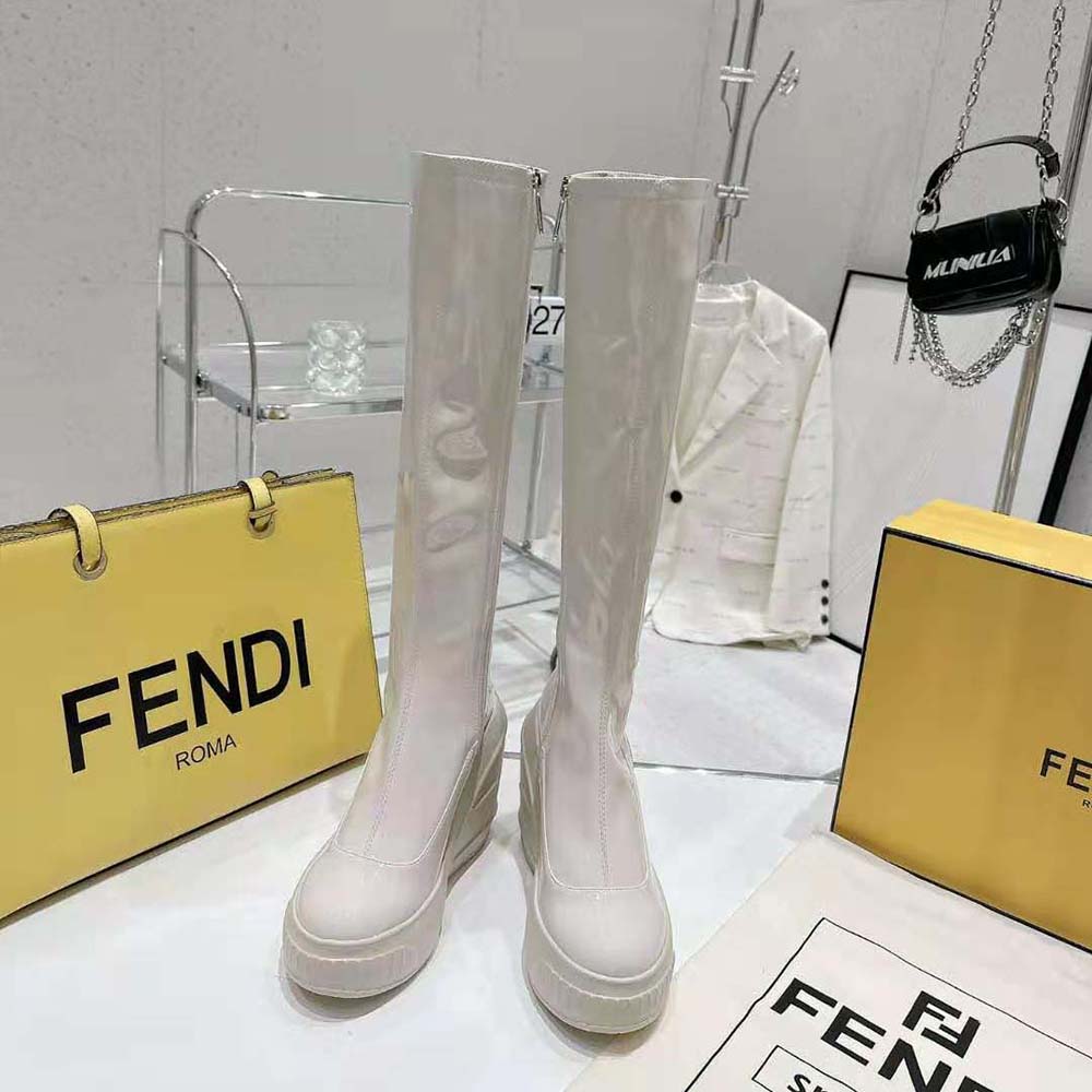 Close-up of gold-tone hardware on Fendi white patent leather boots
