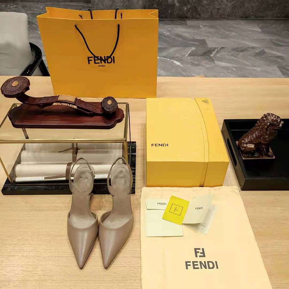 Close-up of gold-tone Fendi logo on slingback strap, dove gray leather