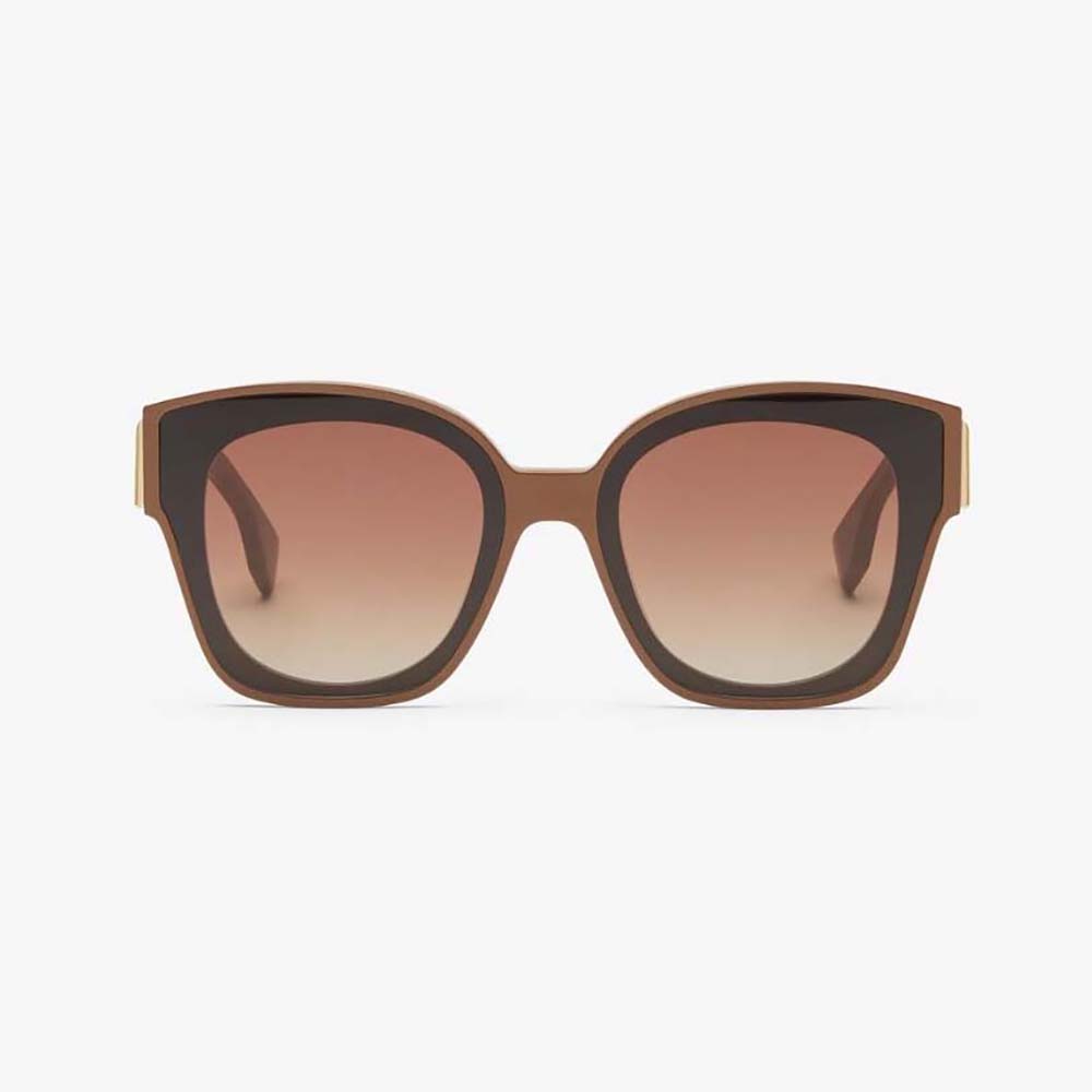 Close-up of gold Fendi logo hardware on caramel acetate sunglasses arm