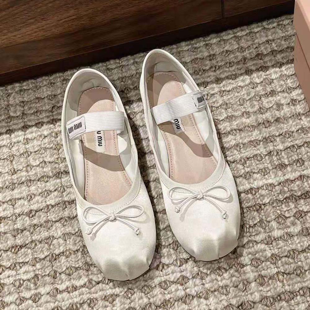 Close-up of knit logo label on white satin ballerina toe
