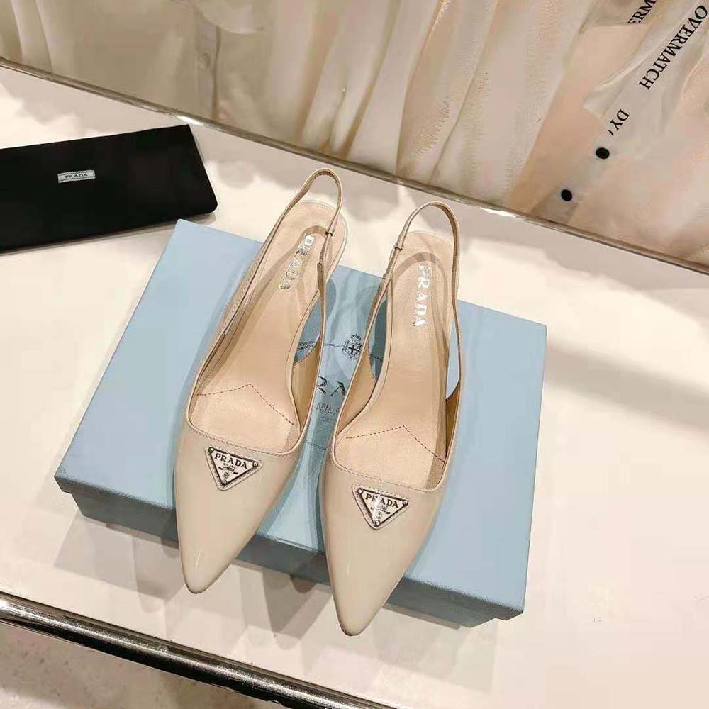 Close-up of patent leather and Prada hardware on slingback pumps in white