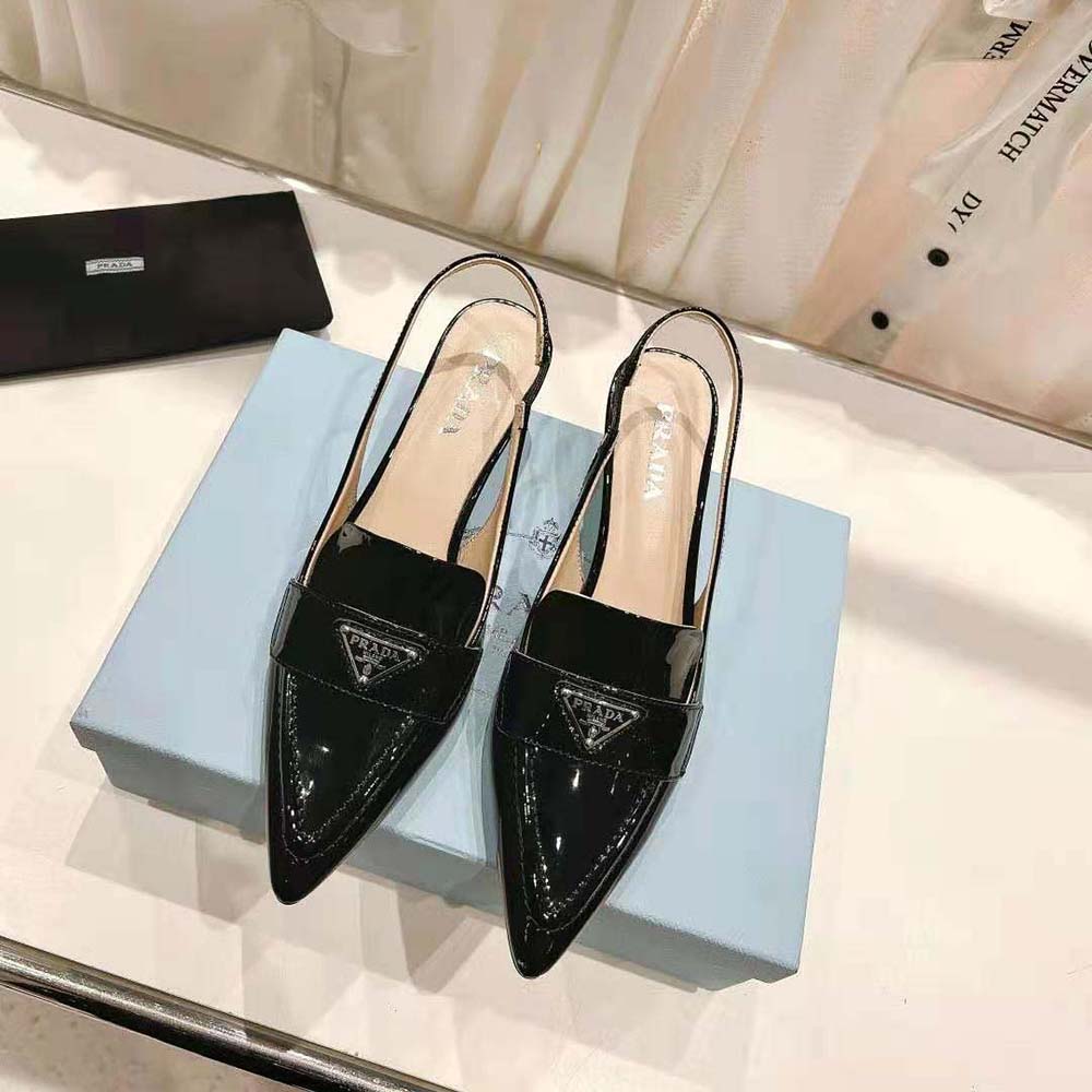 Close-up of glossy black patent leather and Prada logo hardware detail
