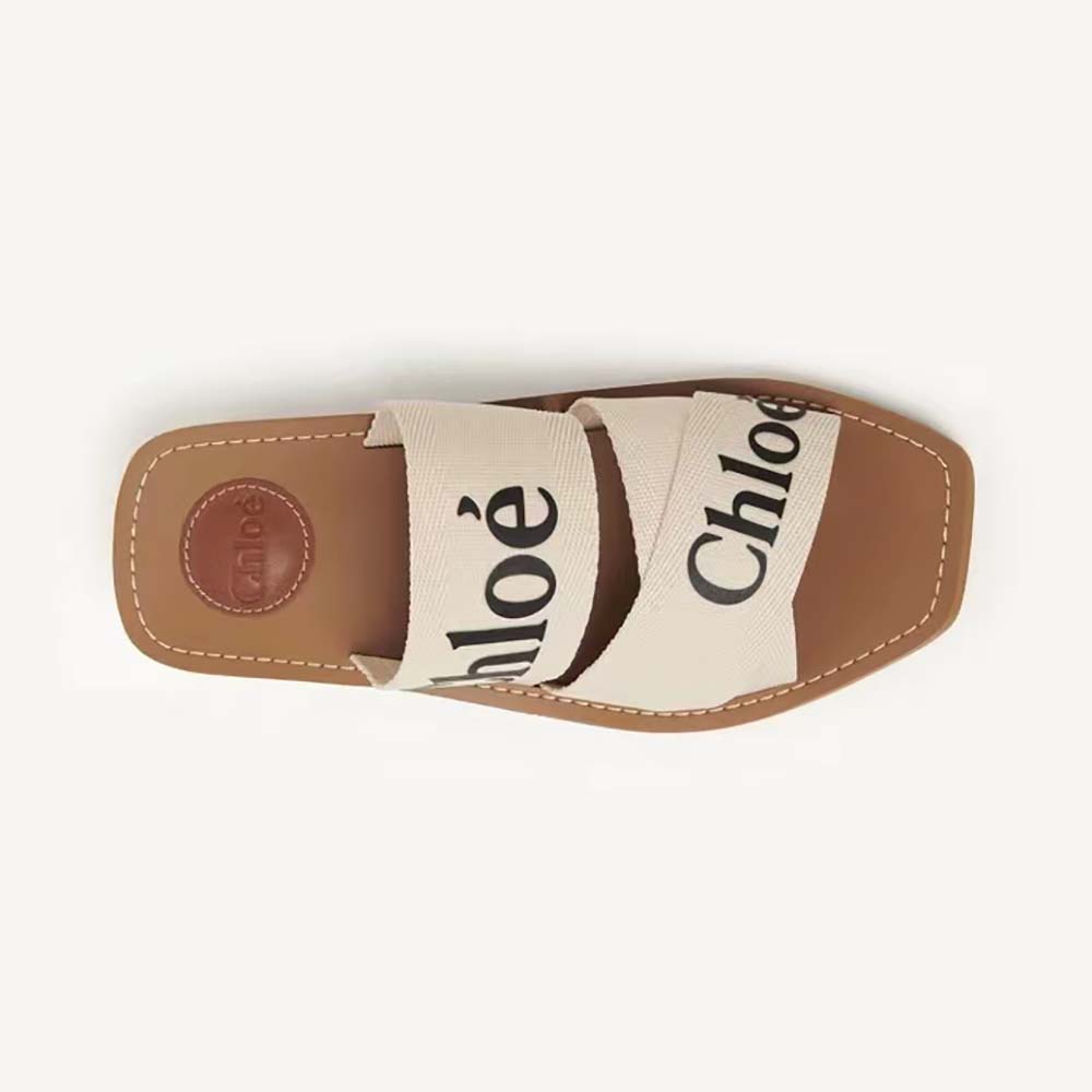 Side angle of Chloe Women Woody Flat Mule in Canvas-Beige showing wooden sole